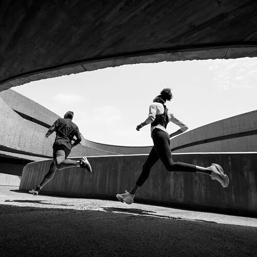 Two people running in an urban architectural setting.