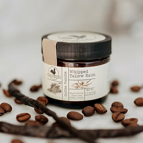 Jar of whipped tallow balm with coffee beans and vanilla.