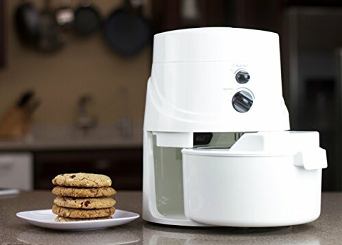 White kitchen mixer on counter with stacked cookies on a plate.