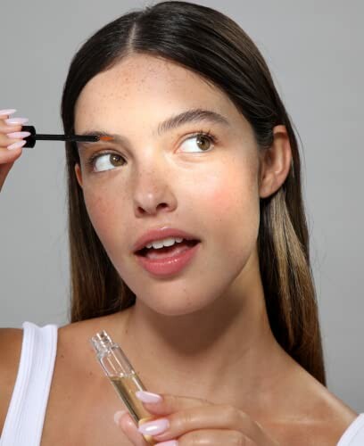 Woman applying eyebrow gel with a brush