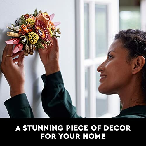 Woman hanging colorful floral decor on wall