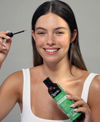 Woman applying product with castor oil bottle