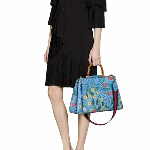 Woman in black dress holding a blue floral handbag