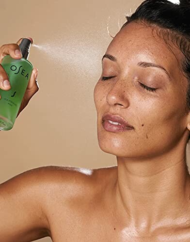 Woman applying facial mist to her face