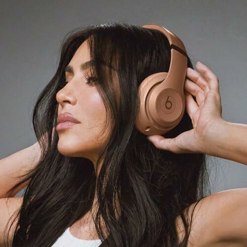 Woman wearing rose gold Beats headphones