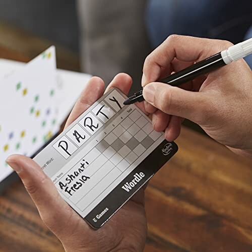 Person writing on a Wordle game card with a marker.